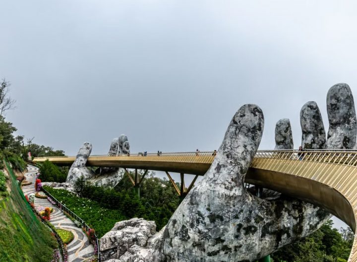 Explore the iconic Golden Bridge in Da Nang, Vietnam, held by giant stone hands amidst lush greenery.
